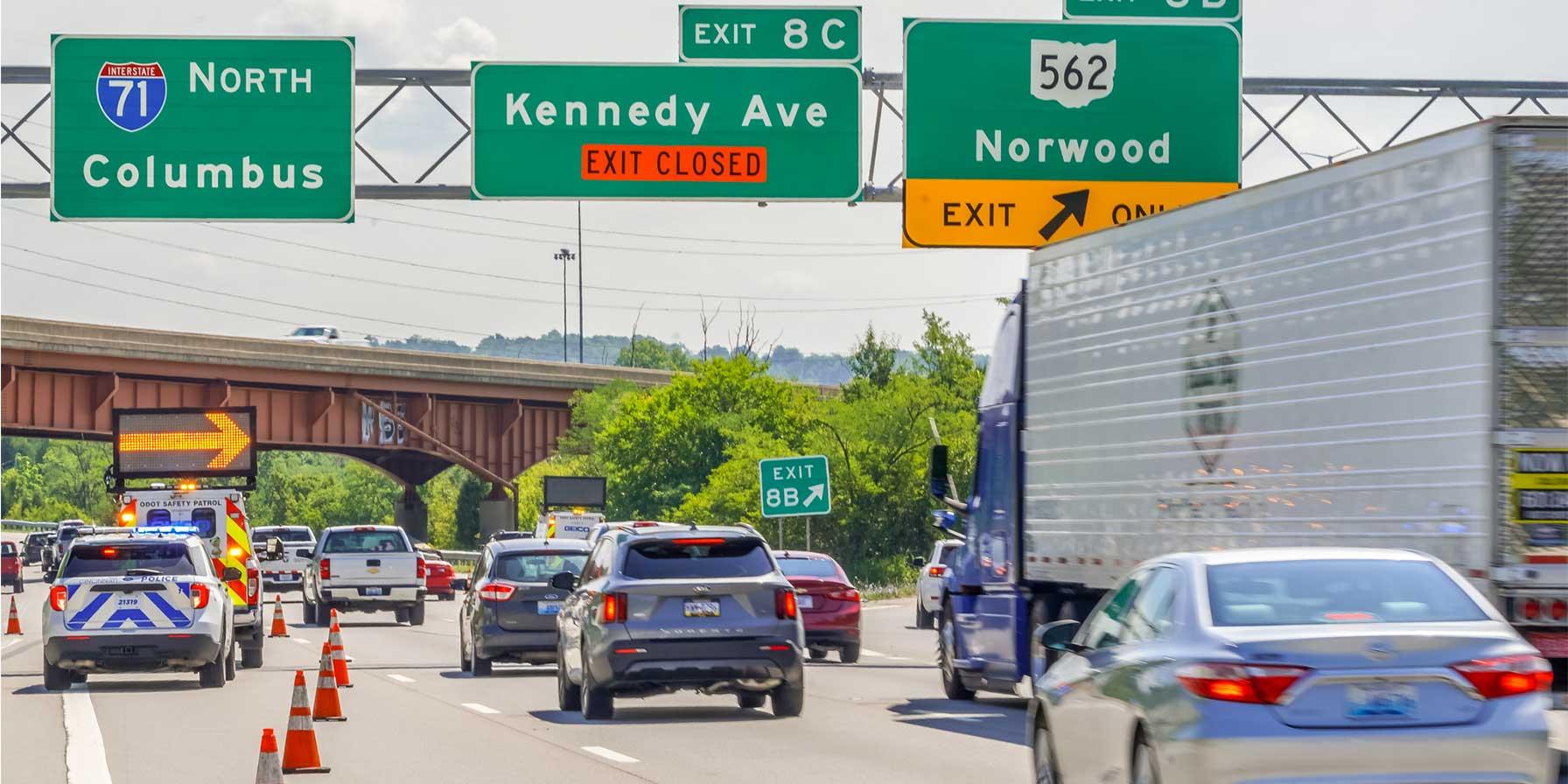 Highway scene with traffic, police vehicle, and lane closure